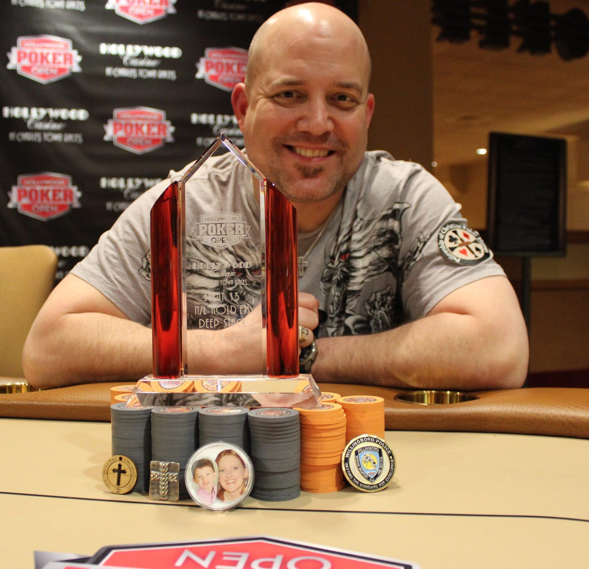 Lee Childs smiling with a Hollywood Poker Open trophy and poker chips